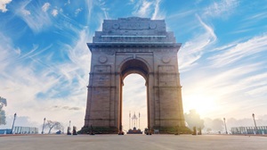 India Gate at sunset with visitors on the lawns